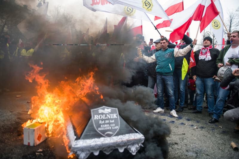 Farmers burn a coffin symbolizing the death of Polish agriculture on a bonfire outside the prime minister's office during the demonstration. Attila Husejnow/SOPA Images via ZUMA Press Wire/dpa