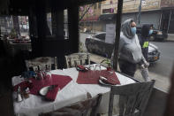 San Gennaro restaurant is closed but the tables are set in the Bronx borough of New York on Friday, April 17, 2020, during the coronavirus pandemic. The New York City immortalized in song and scene has been swapped out for the last few months with the virus version. In all the unknowing of what the future holds, there's faith in that other quintessential facet of New York City: that the city will adapt. (AP Photo/Mark Lennihan)