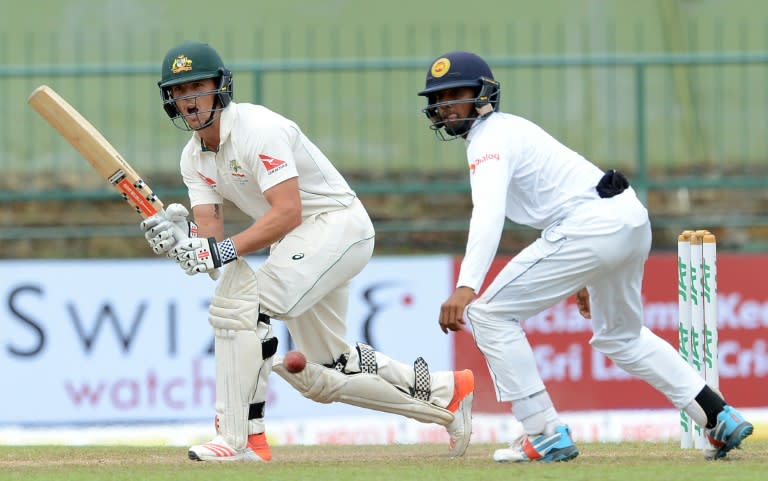 Australia's Steve O'Keeffe (L) plays a shot as Sri Lanka's Kusal Mendis (R) looks on, during the final day of the first Test in Pallekele on July 30, 2016