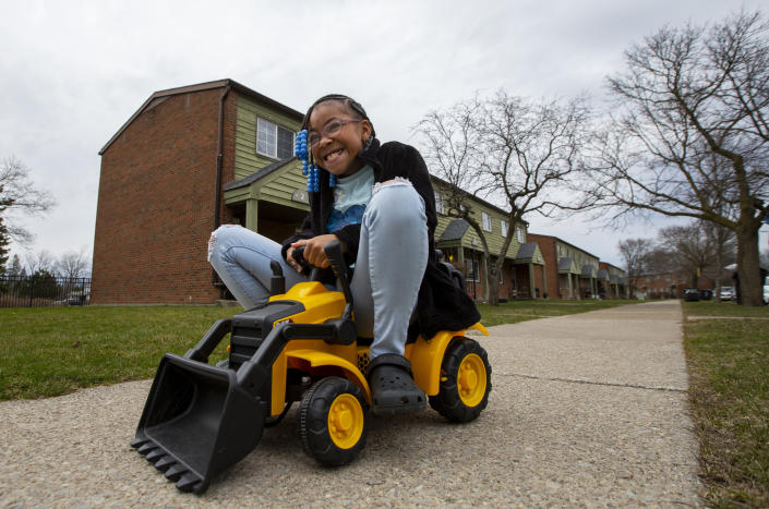 Ke'Arrah Jessie, 9, plays with one of her brother's toys outside of their apartment in Niagara Falls, N.Y., on Monday, April 3, 2023. (AP Photo/Lauren Petracca)