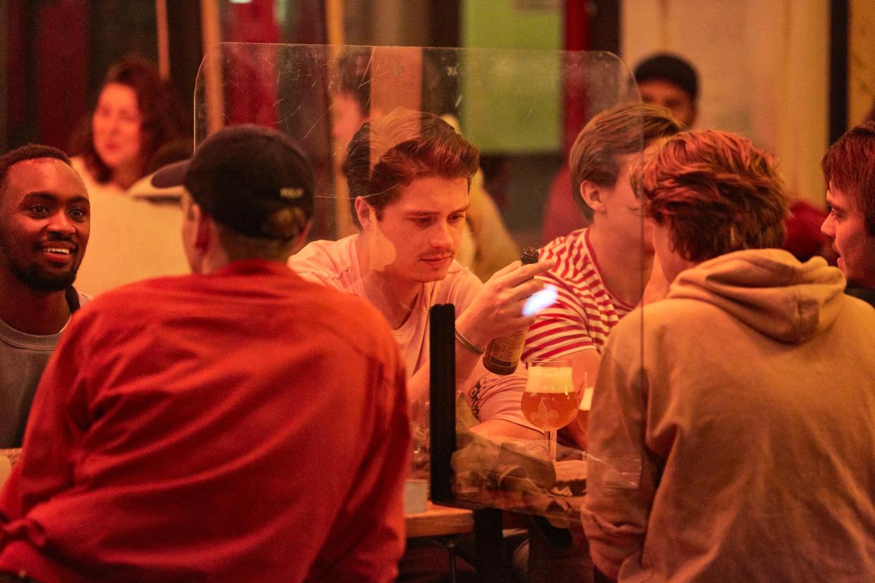 People separated by plastic curtains drink on a terrace on Sept. 21, 2020 in Amsterdam, Netherlands. Due to the rapid rise in new coronavirus cases, Dutch authorities have imposed a 1 a.m. curfew on bars and restaurants in Amsterdam and other major cities. The Netherlands has reported some 90,047 coronavirus cases, with 2000 new recorded cases in the last 24 hours.