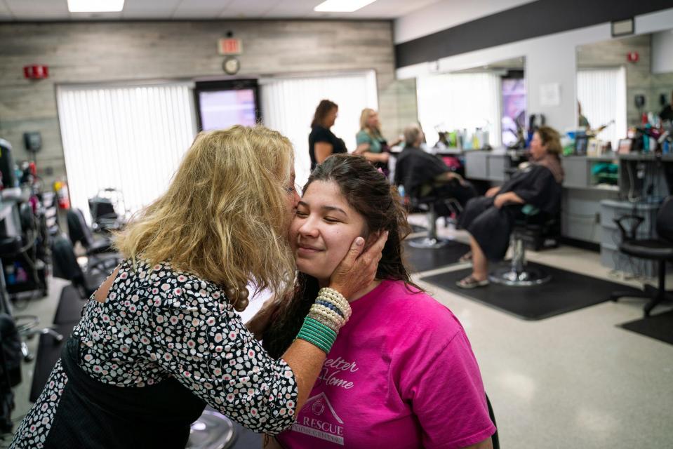Hairstylist Nikki Elias-Porter, 68, of Dearborn, kisses Emilie Nieves, 19, of Allen Park, on the cheek after perming her hair at Anthony's Hair Inc in Allen Park on July 25, 2023.