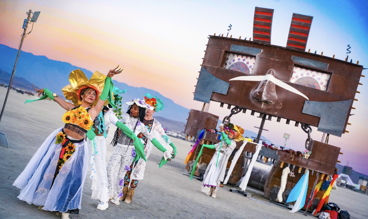 A vibrant procession of Burners dancing through the desert. 