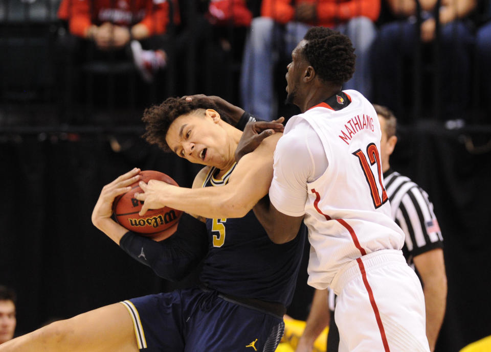 <p>Michigan Wolverines forward D.J. Wilson (5) battles for the ball with Louisville Cardinals forward Mangok Mathiang (12) during the first half in the second round of the 2017 NCAA Tournament at Bankers Life Fieldhouse. Mandatory Credit: Thomas Joseph-USA TODAY Sports </p>