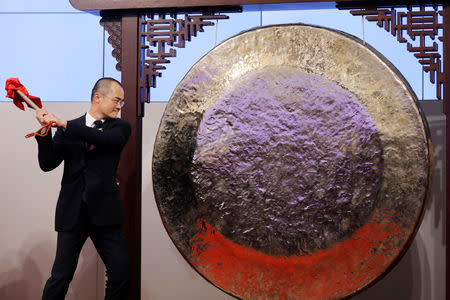 Wang Xing, co-founder, chairman and chief executive officer of China's Meituan Dianping hits the gong during the debut of the company at the Hong Kong Exchanges in Hong Kong, China September 20, 2018. REUTERS/Tyrone Siu