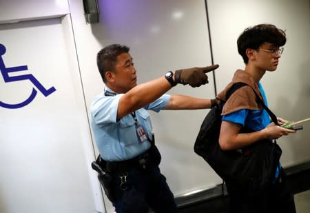 A police officer disperses a man inside Hong Kong International Airport, Hong Kong, China