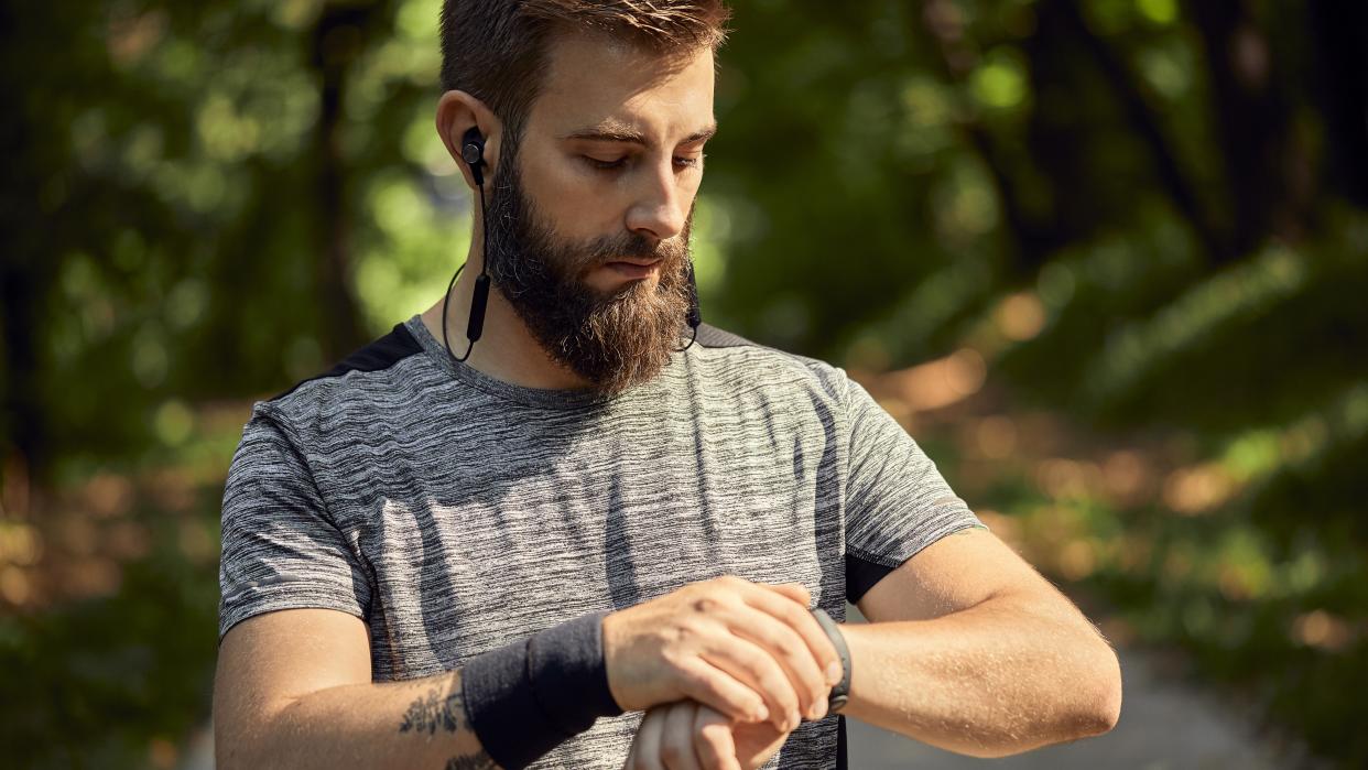  Bearded man using GPS watch. 