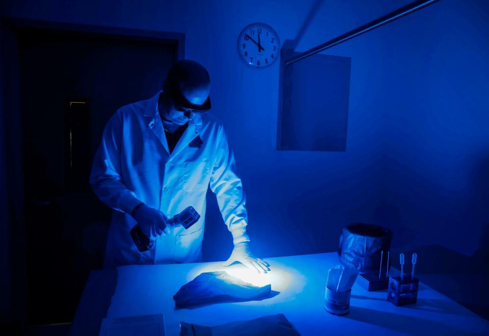 Mike Halverson, a DNA technical leader at the Iowa Division of Criminal Investigation lab in Ankeny, demonstrates how rape evidence is collected using an alternative light source on Friday, Sept. 8, 2017.