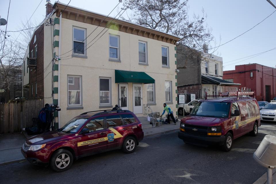 A Member of the Pennsylvania Society for the Prevention of Cruelty to Animals brings in boxes to remove cats from two connected row homes Wednesday, March 26, 2014, in Philadelphia. The Animal welfare authorities say they are working to remove about 260 cats and take them to the organization's north Philadelphia shelter, where veterinarians were waiting to examine them. (AP Photo/Matt Rourke)