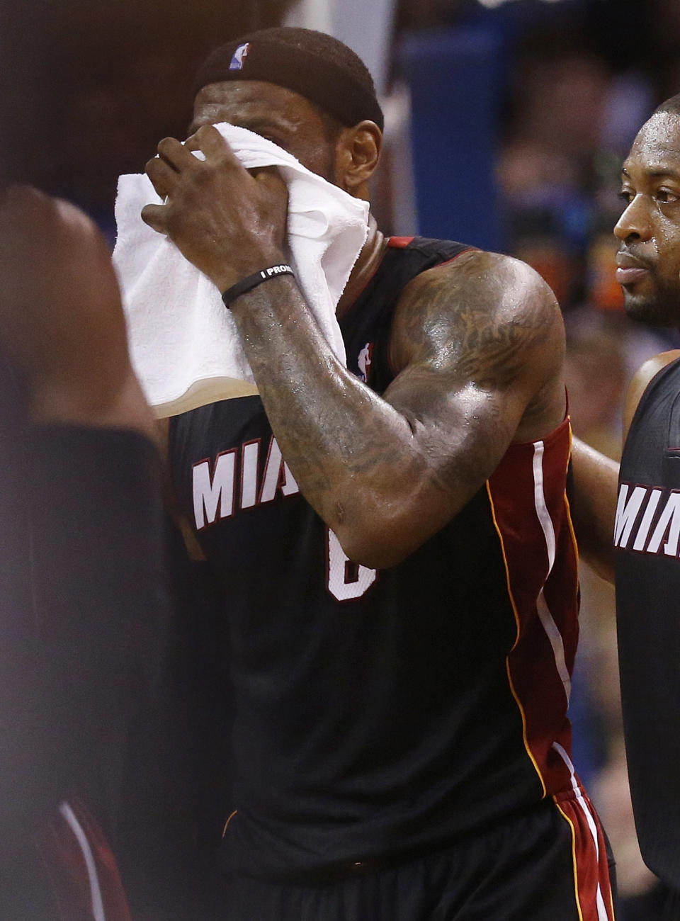 Miami Heat forward LeBron James holds a towel over his face as he walks off the court with a bloody nose during the fourth quarter of an NBA basketball game against the Oklahoma City Thunder in Oklahoma City, Thursday, Feb. 20, 2014. James was struck by Thunder's Serge Ibaka on a drive to the basket. Heat guard Dwyane Wade is at right. Miami won 103-81. (AP Photo/Sue Ogrocki)