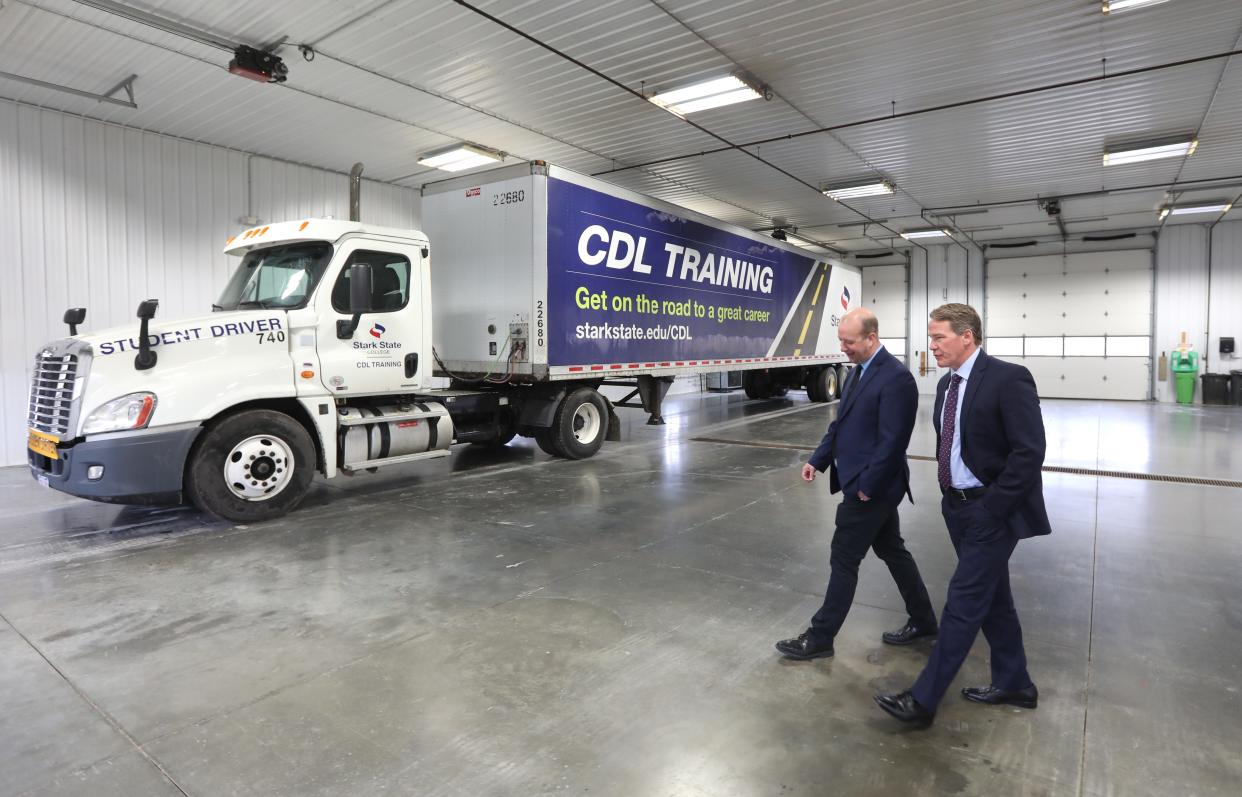 Mid-East Career and Technology Centers Superintendent Matt Sheridan, left, and Lt. Governor Jon Husted walk past a semi truck at Mid-East's CDL training center in Zanesville. Husted visited to tout the $300 million for career centers he and Ohio Gov. Mike DeWine hope to get in the state budget this year. The Stark State truck behind them is part of a partnership between the two schools.