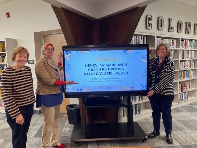 Woodbridge Library Director Monica F. Eppinger, Amera Elbayar, Henry Inman Branch Library manager and Maryann Ralph, Woodbridge Library assistant director, with sign announcing the April 20, 2024 reopening of the Henry Inman Branch Library in the Colonia section