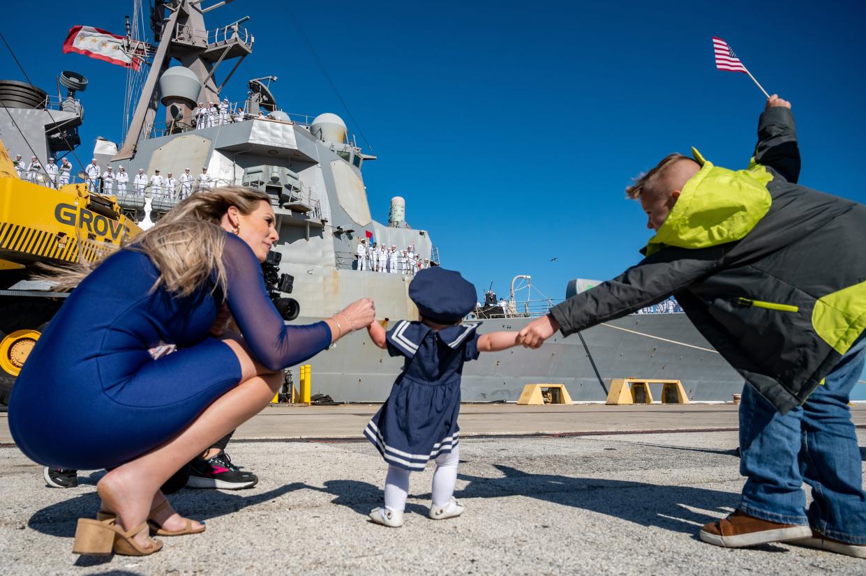 Nine-month-old Brynlee Nelson sees her father waving as she waits with mother Jessica Nelson and brother Blake Sexton, 10, for his return with USS The Sullivans at Naval Station Mayport just in time for the holidays.