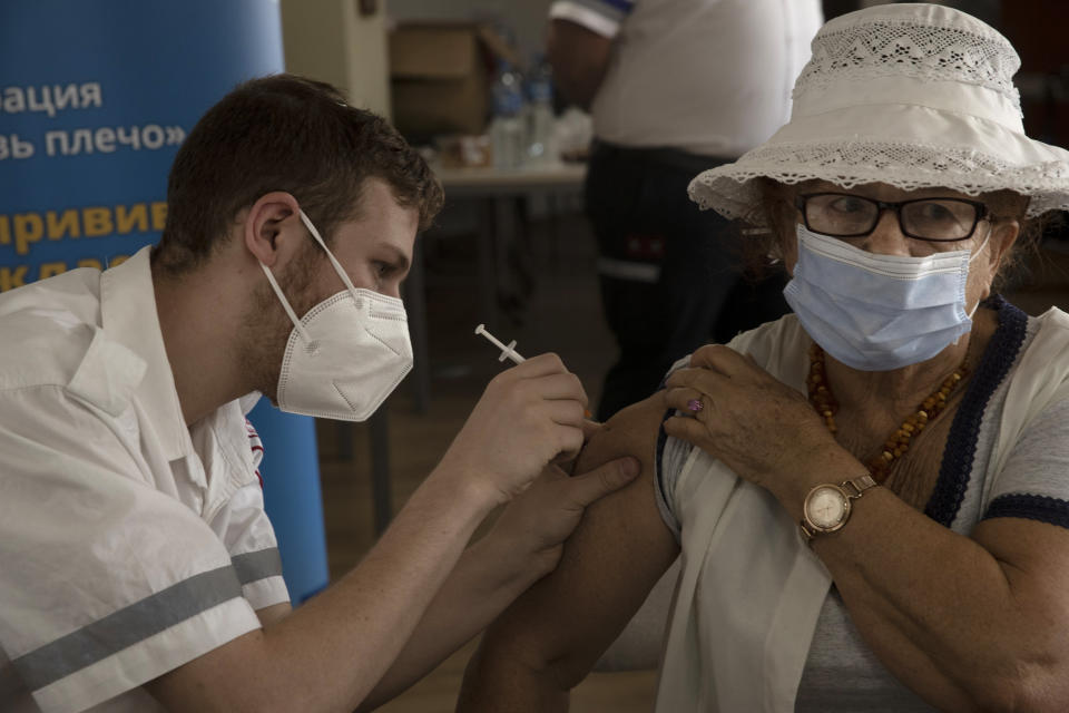 An Israeli woman receives a third coronavirus vaccine injection at a senior center in Jerusalem, Wednesday, Aug. 4, 2021. Israeli health authorities began administering coronavirus booster shots last week to people over 60 who've already received both does of a vaccine, in a bid to combat a recent spike in cases. (AP Photo/Maya Alleruzzo)