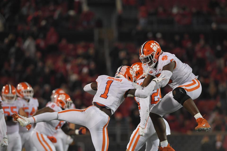 Clemson defender Andrew Makuba celebrates with KJ Henry after he ran down and tackled Louisville quarterback Malik Cunningham during the fourth quarter at Cardinal Stadium in Louisville, Kentucky Saturday, November 6, 2021.