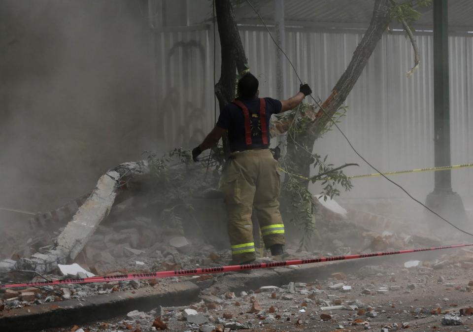 A firefighter works among the rubble of a damaged wall of a building, after a 6.4 magnitude earthquake in Mexico City May 8, 2014. A 6.4 magnitude earthquake shook Mexico City on Thursday, rattling buildings and prompting office evacuations, but there were no immediate reports of damage. (REUTERS/Henry Romero)