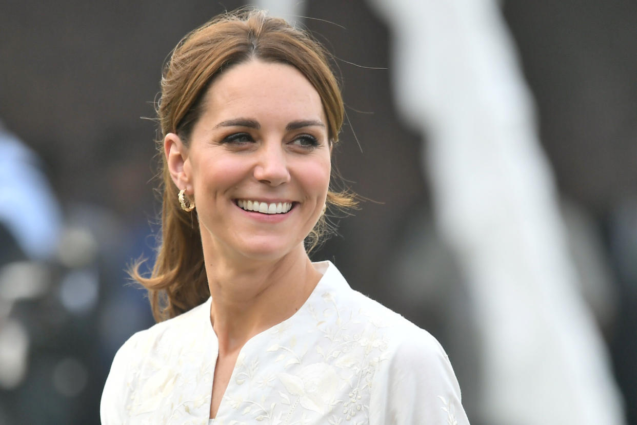 kate middleton, kate middleton with brown hair in pony tail smiling wearing white shirt, LAHORE, PAKISTAN - OCTOBER 17: Catherine, Duchess of Cambridge smiles during a visit of the National Cricket Academy with Prince William, Duke of Cambridge on October 17, 2019 in Lahore, Pakistan. Their Royal Highnesses The Duke and Duchess of Cambridge are on a visit of Pakistan between 14-18th October at the request of the Foreign and Commonwealth Office. (Photo by Samir Hussein/WireImage)