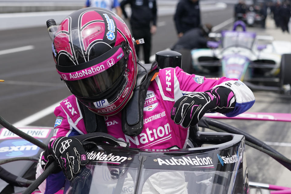 Helio Castroneves, of Brazil, climbs out of his car during IndyCar auto racing testing at Indianapolis Motor Speedway, Wednesday, April 20, 2022, in Indianapolis. (AP Photo/Darron Cummings)