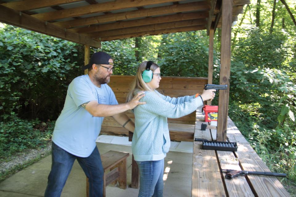 Daryl Bowe of Blissfield helps his daughter Tara, 12, with her stance Saturday, Aug. 6, 2022, while shooting a pistol at the Lenawee County Conservation League.