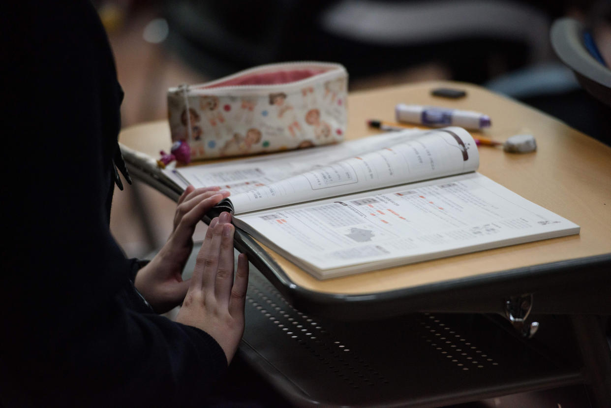 South Korean student reading a textbook in class