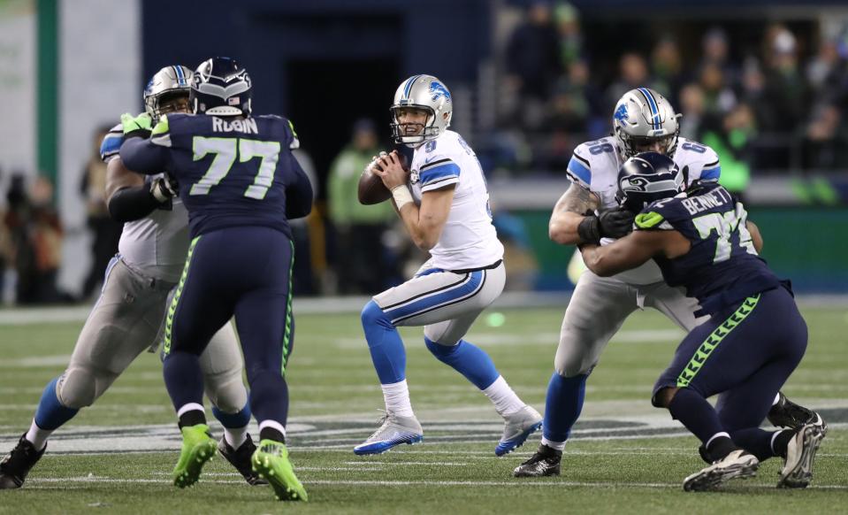 Lions quarterback Matthew Stafford looks to pass while left tackle Taylor Decker, right, blocks Seahawks defensive end Michael Bennett during the third quarter of an NFL playoff game Saturday, Jan. 7, 2017 at CenturyLink Field in Seattle.