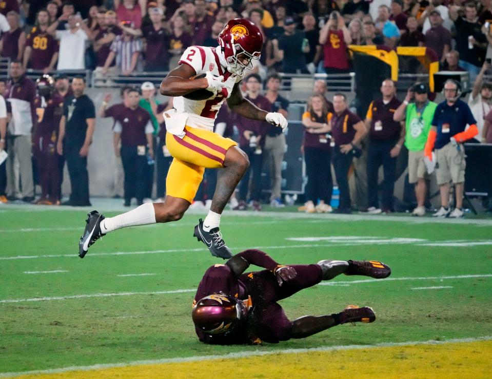 Sep 23, 2023; Tempe, Arizona, USA; USC Trojans wide receiver Brenden Rice (2) jumps over Arizona State Sun Devils defensive back Demetries Ford (4) to score a touchdown in the first half at Mountain America Stadium. Mandatory Credit: Rob Schumacher-Arizona Republic