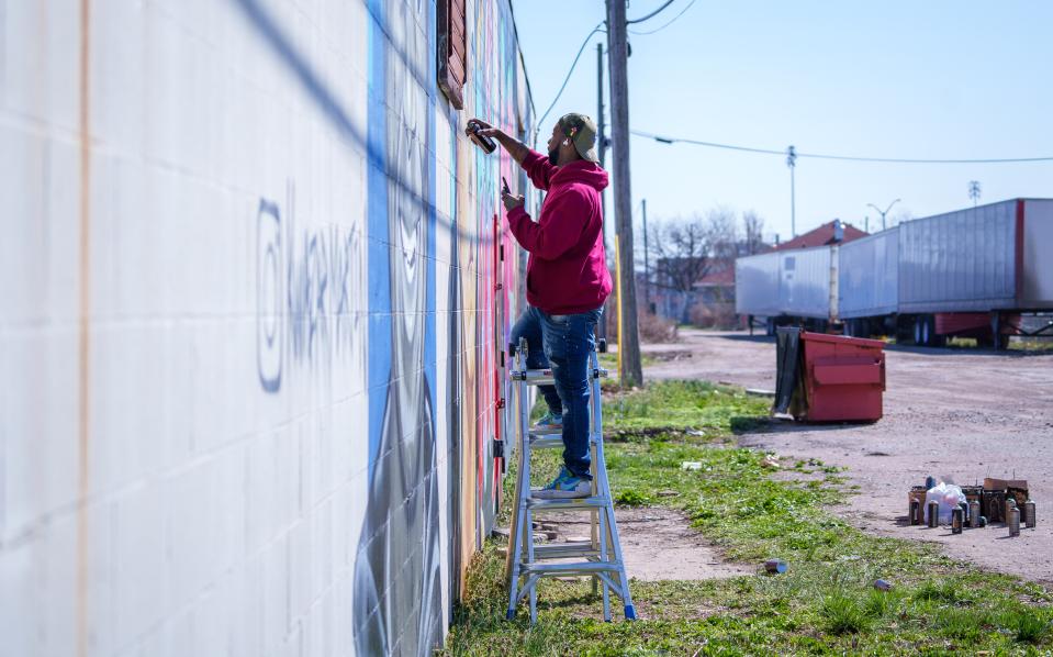 Indianapolis artist Kwazar Martin blends hair highlights Monday, March 11, 2024, as he puts the finishing touches on his most recent work, a graffiti mural of Iowa Hawkeyes basketball player Caitlin Clark. Clark is the community favorite for the Indiana Fever's upcoming No. 1 WNBA draft pick.
