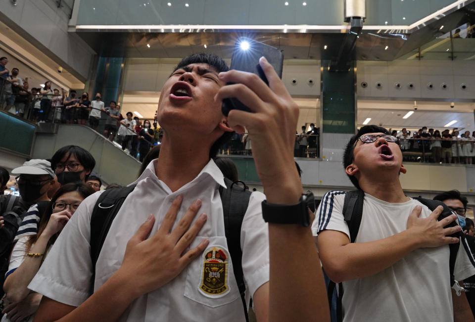 Local residents sing a theme song written by protesters "Glory be to thee" at a shopping mall in Hong Kong Wednesday, Sept. 11, 2019. Hong Kong Chief Executive Carrie Lam reassured foreign investors Wednesday that the Asian financial hub can rebound from months of protests, despite no sign that the unrest will subside. (AP Photo/Vincent Yu)