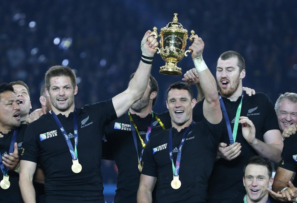 FILE - This is a Saturday, Oct. 31, 2015 file photo, New Zealand's All Blacks captain Richie McCaw, left, and teammate Dan Carter hold the Webb Ellis Cup aloft after the Rugby World Cup final between New Zealand and Australia at Twickenham Stadium in London. World Cup-winning All Blacks flyhalf Dan Carter is poised to make a surprise return to Super Rugby in New Zealand at the age of 38. Carter is expected to sign on as an injury replacement with the Blues, joining current All Blacks No. 10 Beauden Barrett at the Auckland-based franchise for the upcoming Super Rugby Aotearoa tournament (AP Photo/Christophe Ena, File)