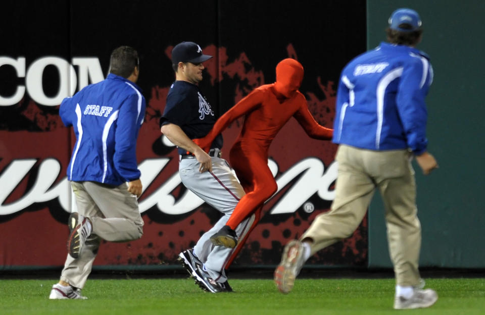 Matt Diaz #23 of the Atlanta Braves tries to trip up a fan that ran onto the field during the game against the Philadelphia Phillies on September 20, 2010 at Citizens Bank Park in Philadelphia, Pennsylvania. (Photo by Drew Hallowell/Getty Images)