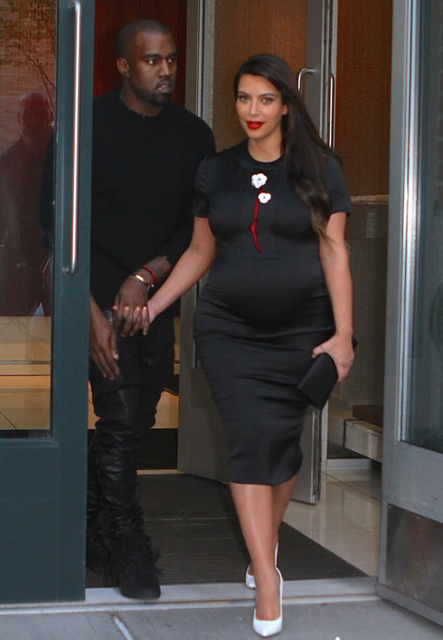 Kim Kardashian opted for a figure-hugging black dress which clung to her baby bump for an outing with Kanye West. Copyright [Splash]