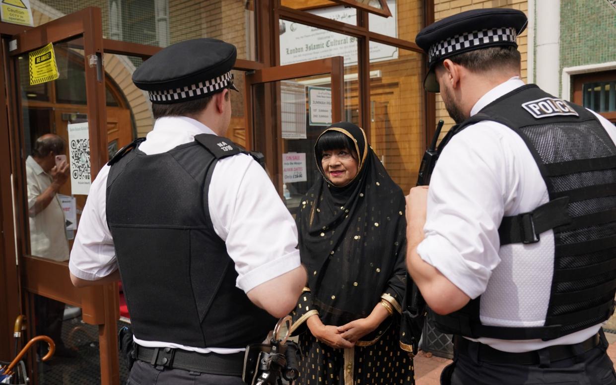 Trustee and president of the London Islamic Cultural Society (LICS) Bibi Rabbiyah Khan speaks to Police officers at the London Islamic Cultural Society (LICS) and Mosque in Haringey