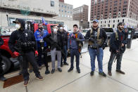 In this April 15, 2020 photo, protesters carry guns outside the Capitol Building in Lansing, Mich. Michigan Attorney General Dana Nessel said Friday, May 8, 2020, that a commission overseeing the state Capitol can legally ban guns from the building, contradicting panel leaders' contention that only the Legislature can do so. (AP Photo/Paul Sancya)