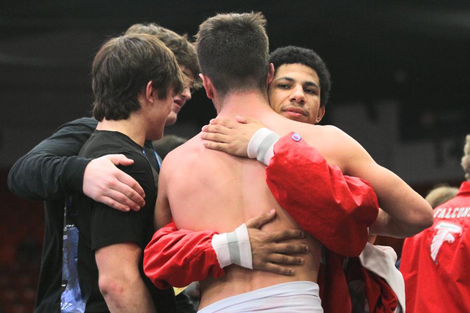 Constantine wrestlers share hugs following the end of the team season at Wings Event Center on Saturday.