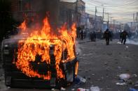 A garbage container burns during protests after a man, who was detained for violating social distancing rules, died from being repeatedly shocked with a stun gun by officers, according to authorities, in Bogota