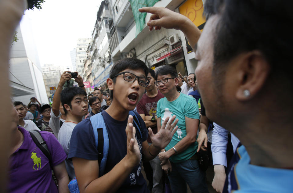 A pro-democracy student protester tries to negotiate with angry locals trying to remove the barricades blocking streets in Causeway Bay, Hong Kong, Friday, Oct. 3, 2014. (AP Photo/Wally Santana)