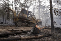 A bulldozer operated by the Forestry Corporation works at building a containment line at a wildfire near Bodalla, Australia, Sunday, Jan. 12, 2020. Authorities are using relatively benign conditions forecast in southeast Australia for a week or more to consolidate containment lines around scores of fires that are likely to burn for weeks without heavy rainfall. (AP Photo/Rick Rycroft)