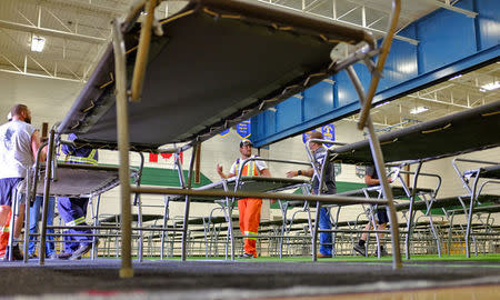 City public works employees Jake LeBrun and Jordan Wiseman set up cots for wildfire evacuees, after they arrived from National Emergency Support Service storage in Prince George, British Columbia, Canada July 10, 2017. Rob van Adrichem/City of Prince George/Handout via REUTERS