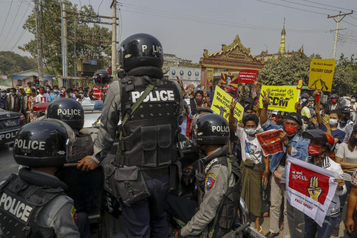 Police stand guard as demonstrators protest against the military junta's arrest and chagrining of National League for Democracy party lawmakers, Mandalay region Chief Minister Zaw Myint Maung & Mayor Ye Lwin outside Aung Myay Thar Zan Township court in Mandalay, Myanmar on Thursday, Feb. 18, 2021. Tens of thousands of demonstrators flooded the streets of Myanmar's biggest city Wednesday, in one of largest protests yet of a coup, despite warnings from a U.N. human rights expert that recent troop movements could indicate the military was planning a violent crackdown. (AP Photo)