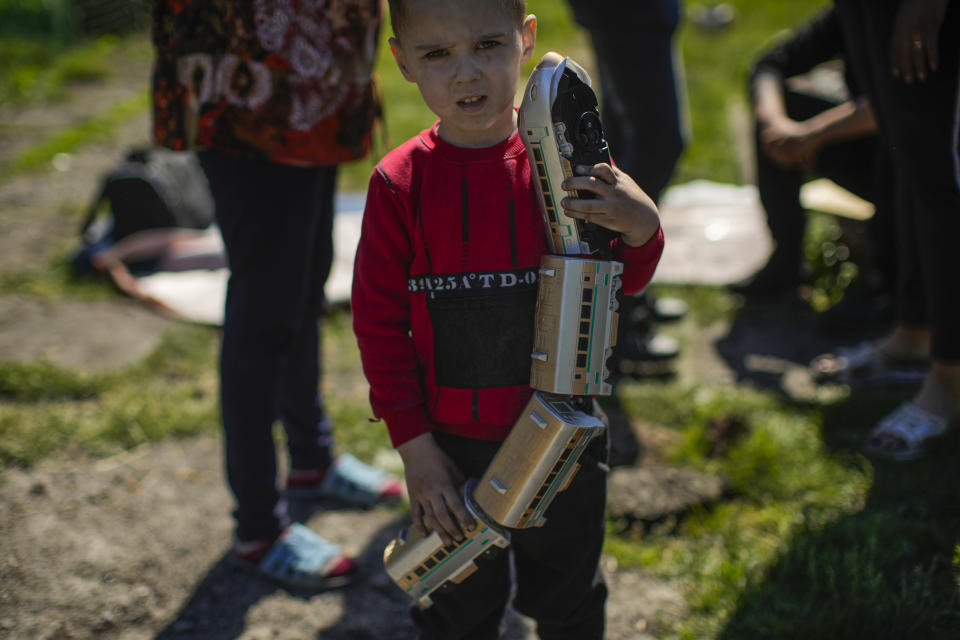 A child holds a toy train outside his family's heavily damaged house after a Russian strike in Pokrovsk, eastern Ukraine, Wednesday, May 25, 2022. Two rockets struck the eastern Ukrainian town of Pokrovsk, in the Donetsk region early Wednesday morning, causing at least four injuries. (AP Photo/Francisco Seco)