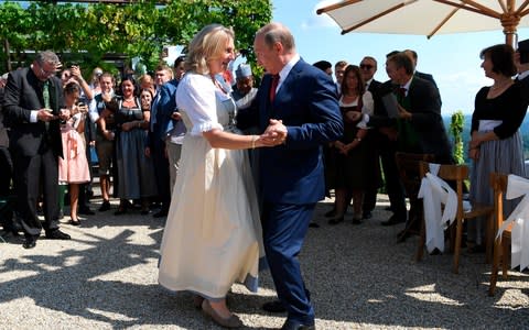 Russian President Vladimir Putin, right, dances with Austrian Foreign Minister Karin Kneissl as he attends the wedding of Kneissl to Austrian businessman Wolfgang Meilinger in Gamlitz, southern Austria - Credit: AP
