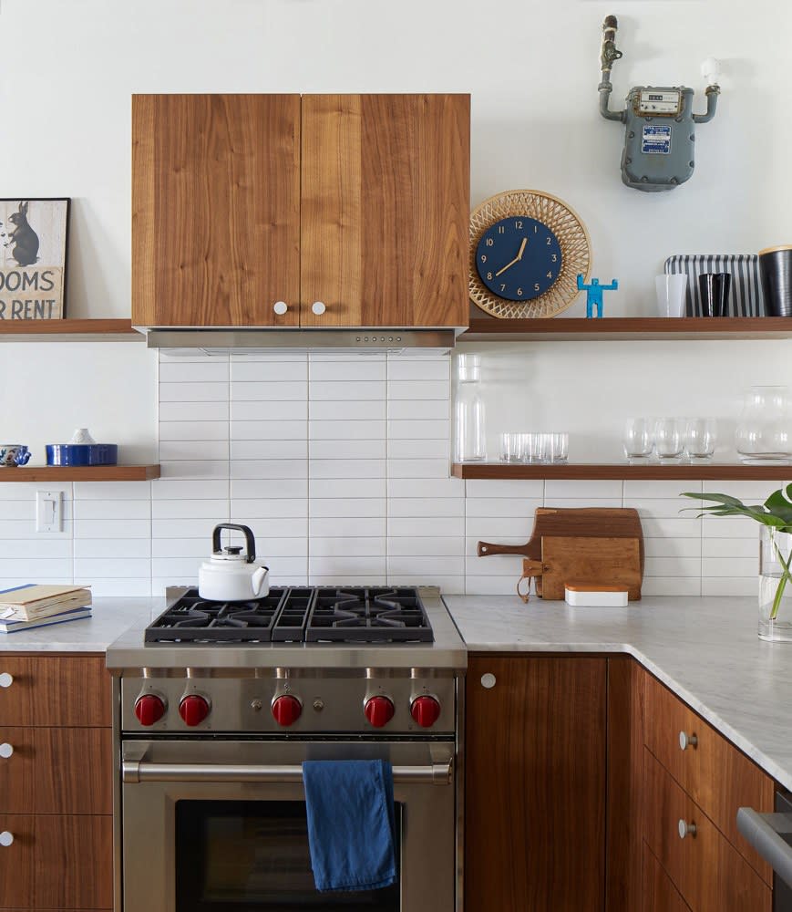 After: The previous version of the kitchen, with white cabinetry and wood countertops, was quite the opposite of the open and airy space the family has now. The update, with its tiled backsplash, new range, and Carrara marble counter, feels modern and built to last.