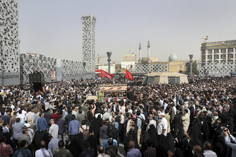 Mourners attend the funeral ceremony of Iran's Revolutionary Guard Col. Hassan Sayyad Khodaei who was killed on Sunday, as a truck carries his flag draped coffin, in Tehran, Iran, Tuesday, May 24, 2022. Iran's hard-line President Ebrahim Raisi vowed revenge on Monday over the killing of Sayyad Khodaei who was shot at his car by two assailants outside his home in Tehran, a still-mysterious attack on the country's powerful paramilitary force. (AP Photo/Vahid Salemi)