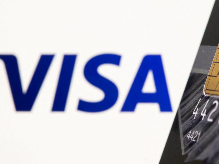 Credit card is seen in front of displayed Visa logo in this illustration taken, July 15, 2021.