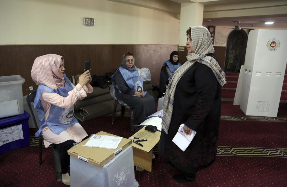 A woman poses for a picture before casting her vote during the Parliamentary election in Kabul, Afghanistan, Saturday, Oct. 20, 2018. Tens of thousands of Afghan forces fanned out across the country as voting began Saturday in the elections that followed a campaign marred by relentless violence. (AP Photo/Rahmat Gul)