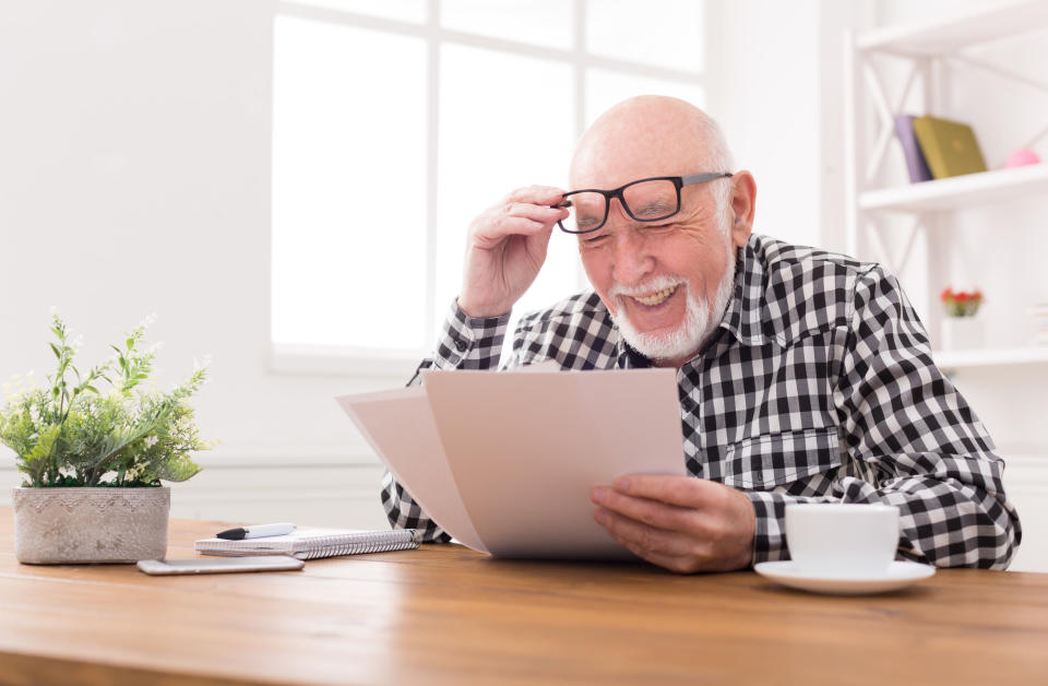 Older man reading papers and squinting.