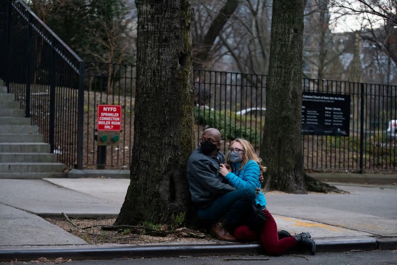 People wearing masks take cover while a man is shooting outside the Cathedral Church of St. John the Divine in Manhattan