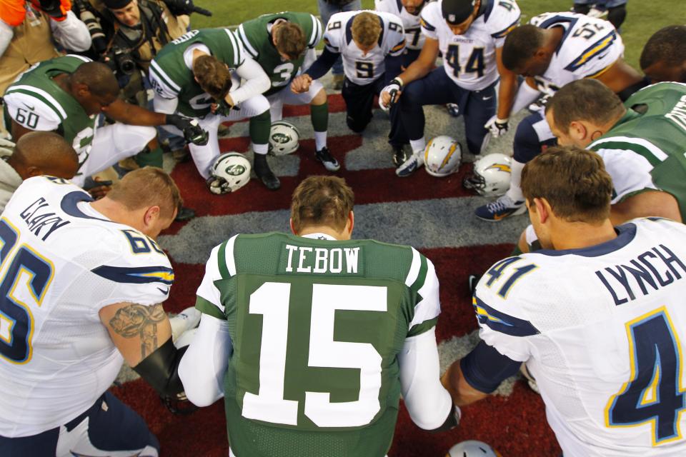 Quarterback Tim Tebow #15 the New York Jets leads a players prayer after their game against the San Diego Chargers at MetLife Stadium on December 23, 2012 in East Rutherford, New Jersey. The Chargers defeated the Jets 27-17. (Photo by Rich Schultz /Getty Images)