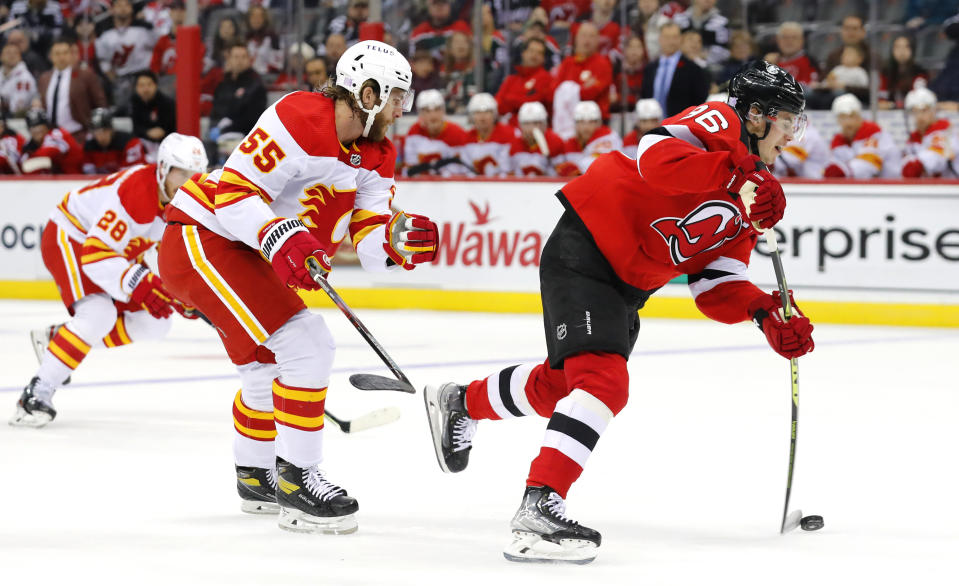 New Jersey Devils center Jack Hughes (86) shoots against Calgary Flames defenseman Noah Hanifin (55) during the first period of an NHL hockey game, Tuesday, Nov. 8, 2022, in Newark, N.J. (AP Photo/Noah K. Murray)