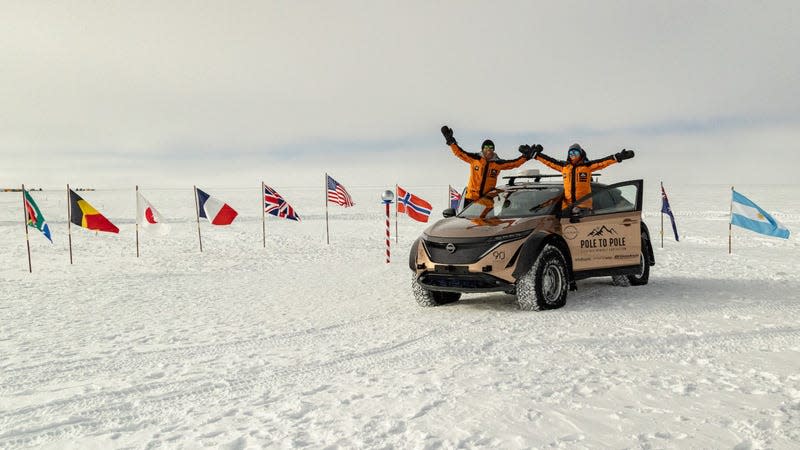 The Ramseys standing up in their Nissan Ariya at the South Pole celebrating their triumph.